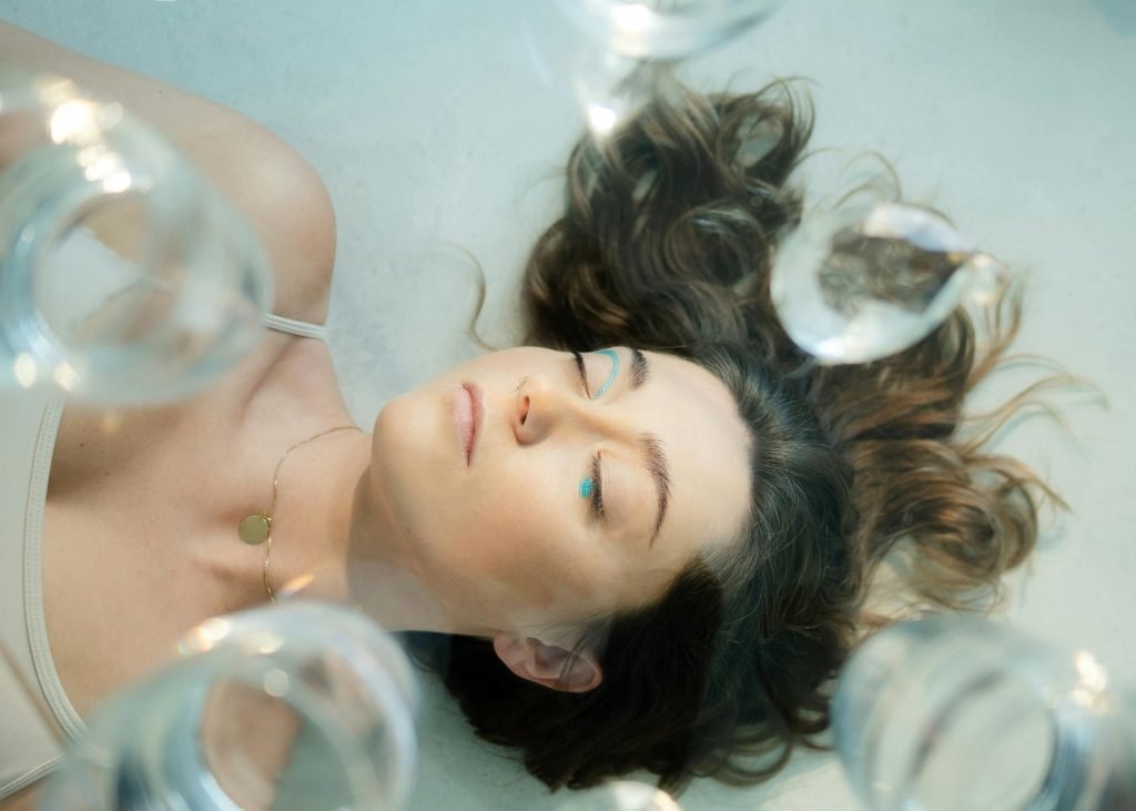 Image dans des tons pastels présentant une femme allongée entourée de bulles méditatives lors de sa pratique de yoga nidra. Laure Colla collaure.com